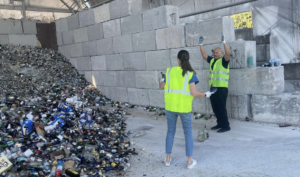 celebrating a day of glass recycling next to a pile of recyclable glass